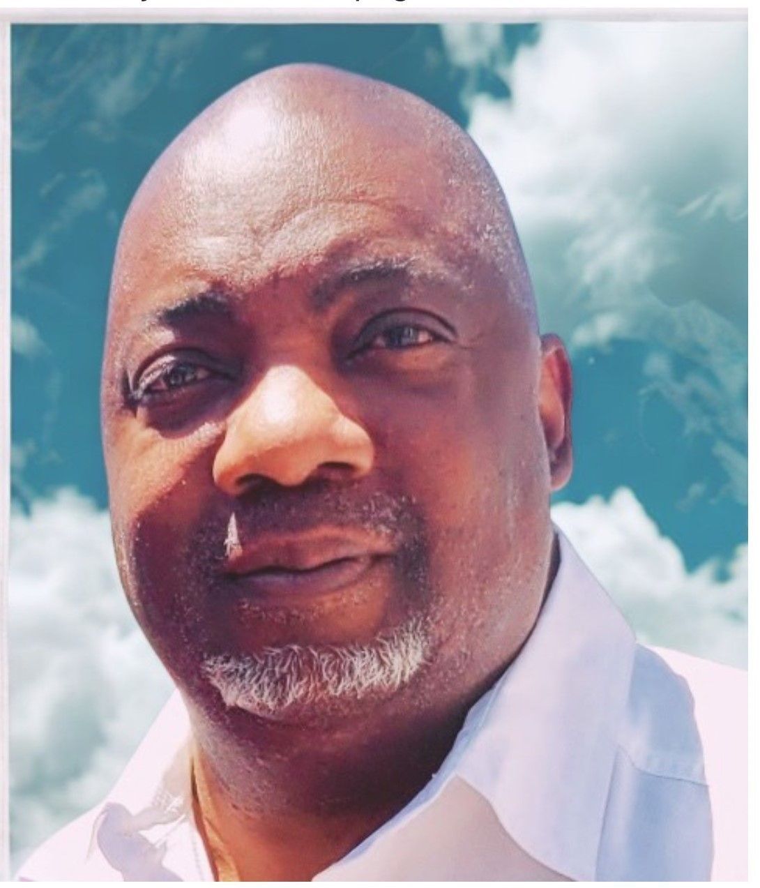 Man in a white shirt outdoors against a bright blue sky with clouds, looking at the camera