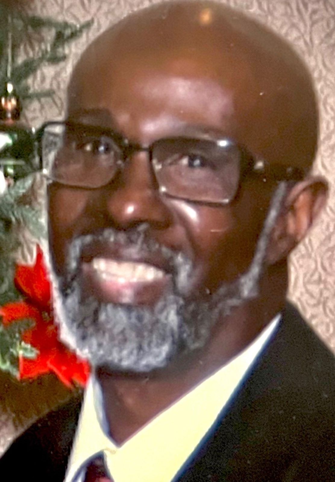 Smiling man in glasses and suit with gray beard at a formal event