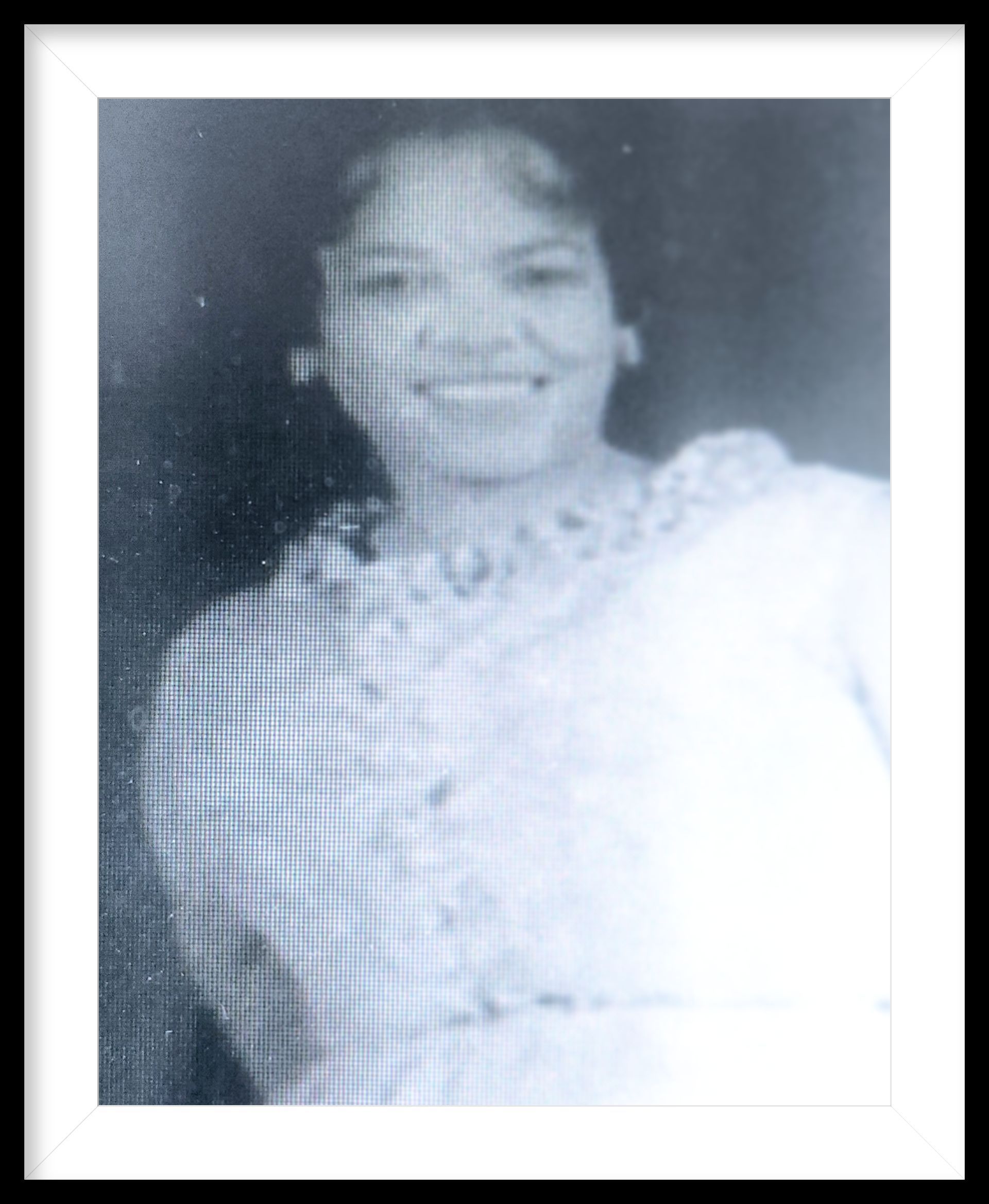 Smiling woman in a patterned dress, shown in a black-and-white portrait.