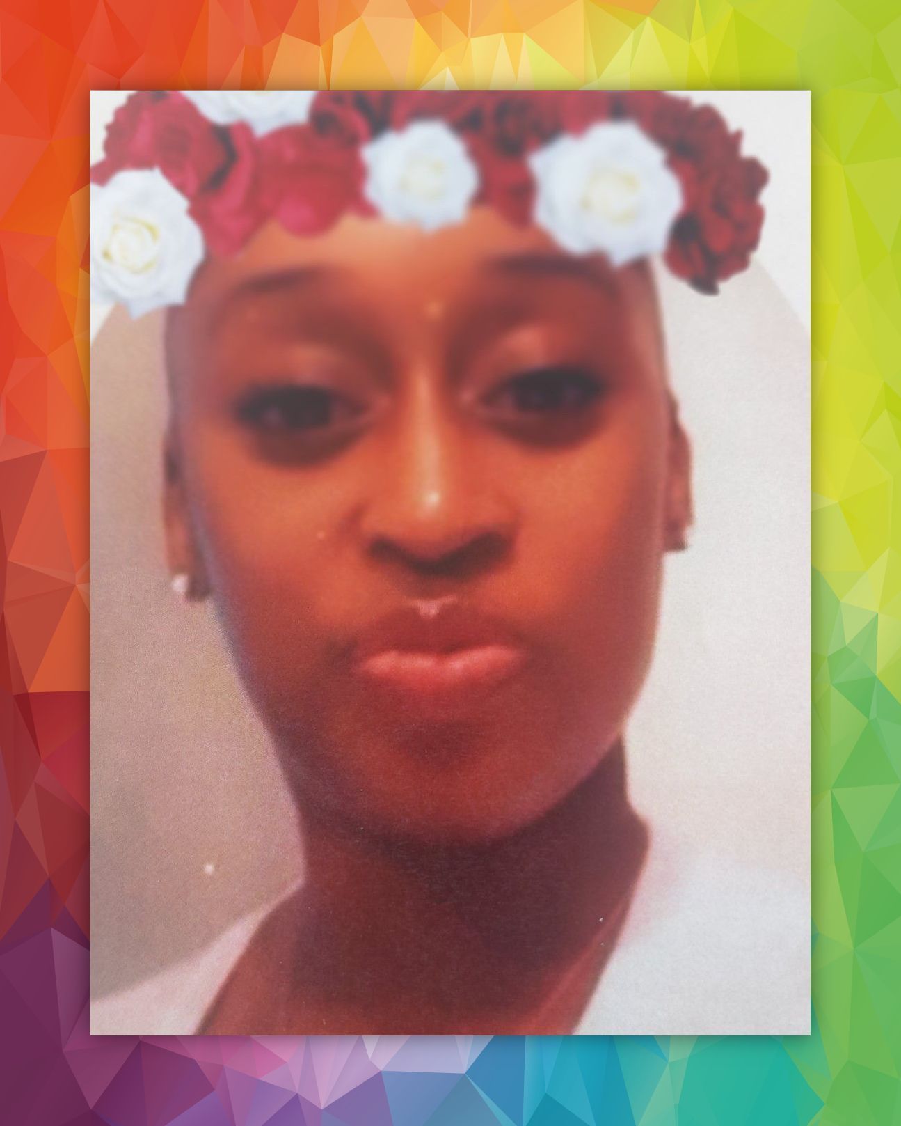 Close-up selfie with a flower crown filter and colorful geometric border, person making a pouty expression