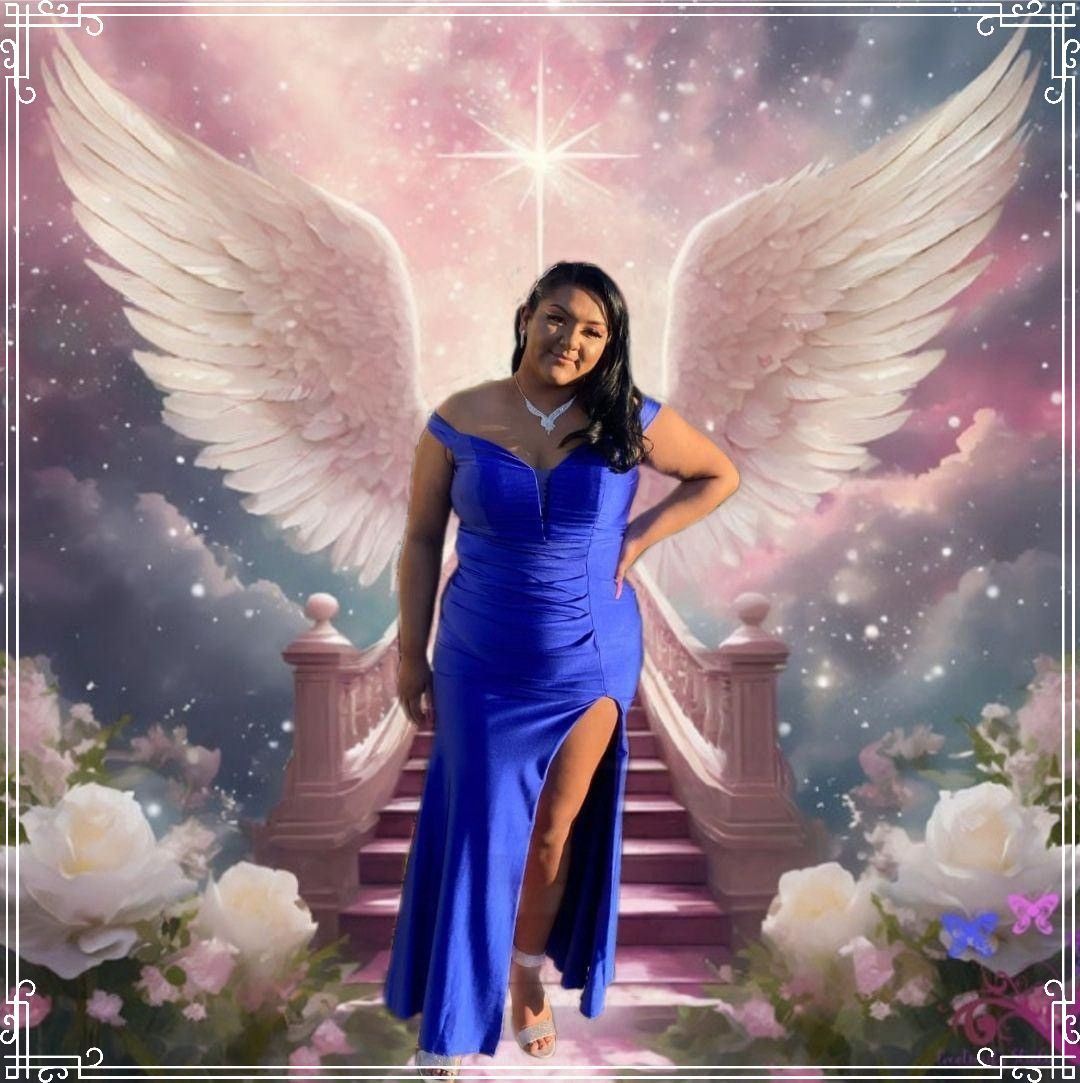 Woman in a bright blue gown standing before angel wings and a starry pink backdrop