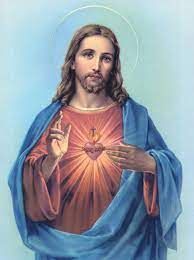 Jesus with halo, pointing to a glowing Sacred Heart, wearing a blue robe on a soft blue background