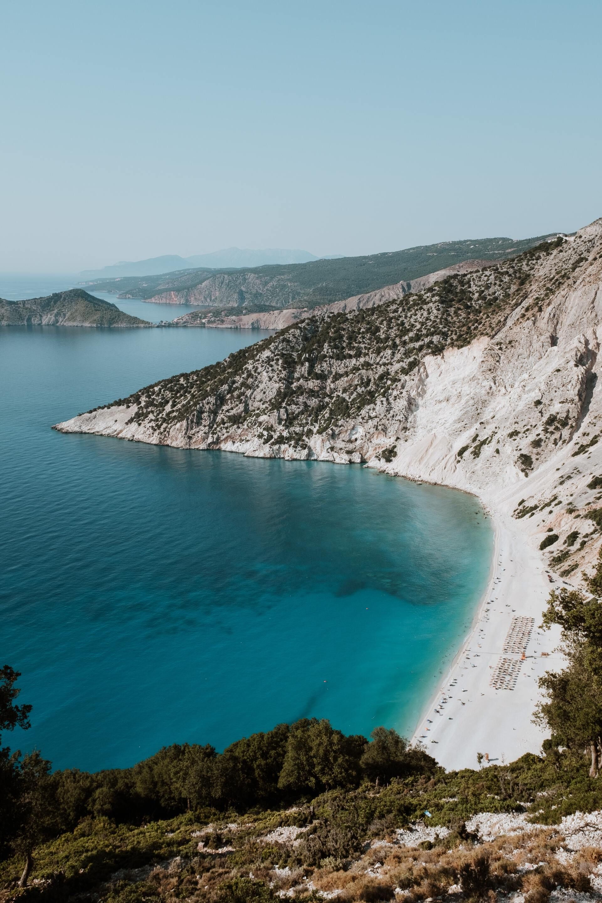 Turquoise bay with white cliffs and a rocky shoreline under a clear sky