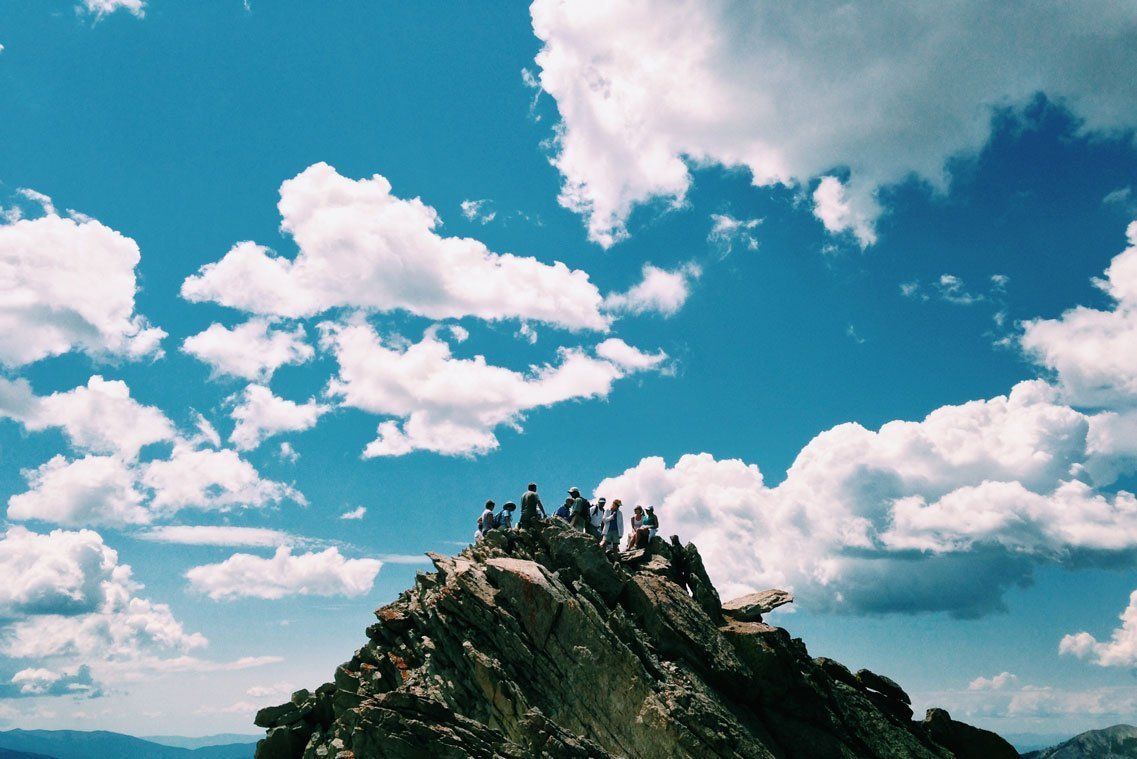 Rocky mountain peak under a bright blue sky with scattered white clouds