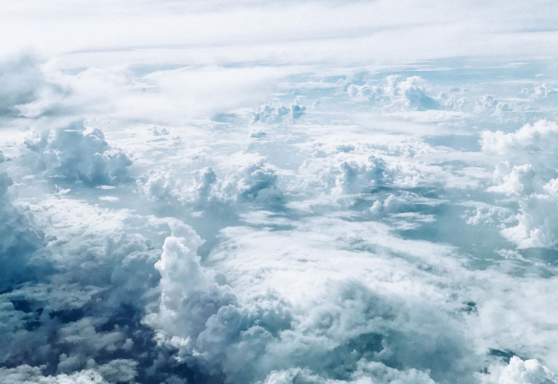 Clouds stretching across a bright blue sky, viewed from above