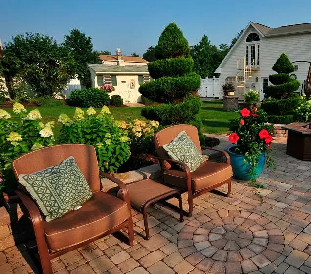 Two chairs and a table on a patio in front of a house