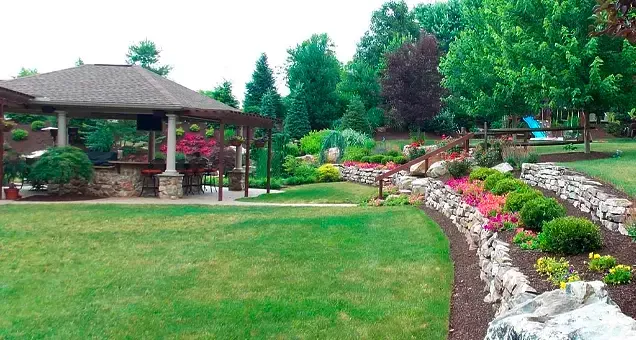 A large lush green lawn with a gazebo in the background.