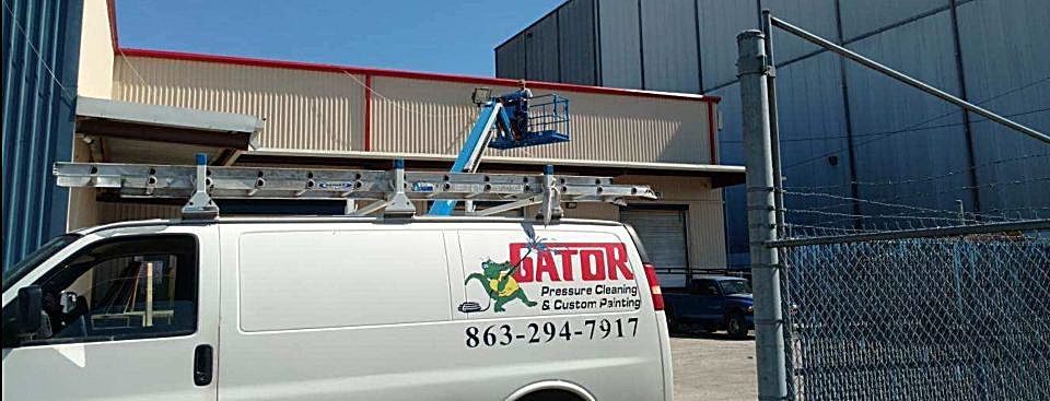 A white van with the word gator on the side is parked in front of a building.