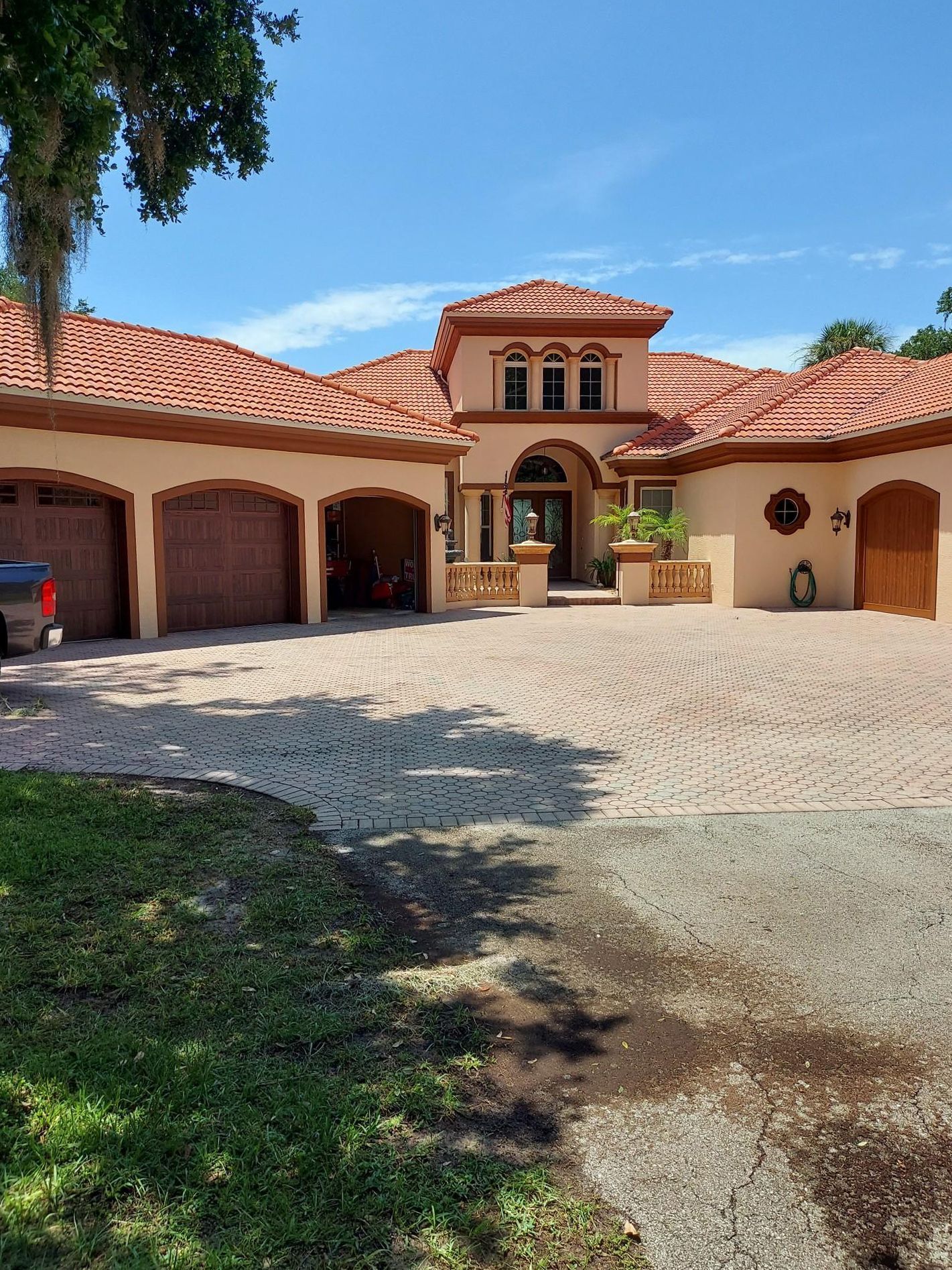 A large house with a red tile roof and a car parked in front of it.
