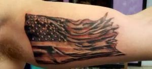 Tattoo of a black-and-red fish with flowing fins on a forearm