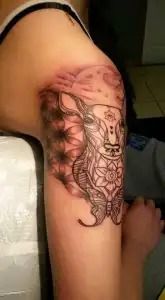 Close-up of a forearm with an intricate black floral tattoo design