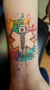 Colorful Type 1 diabetic tattoo with caduceus symbol on a person’s ankle