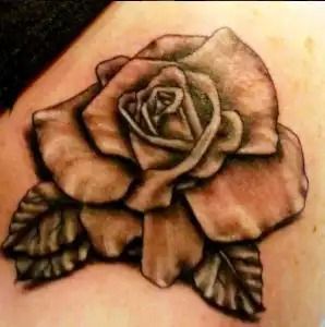 Black-and-gray rose tattoo with detailed petals and leaves on skin