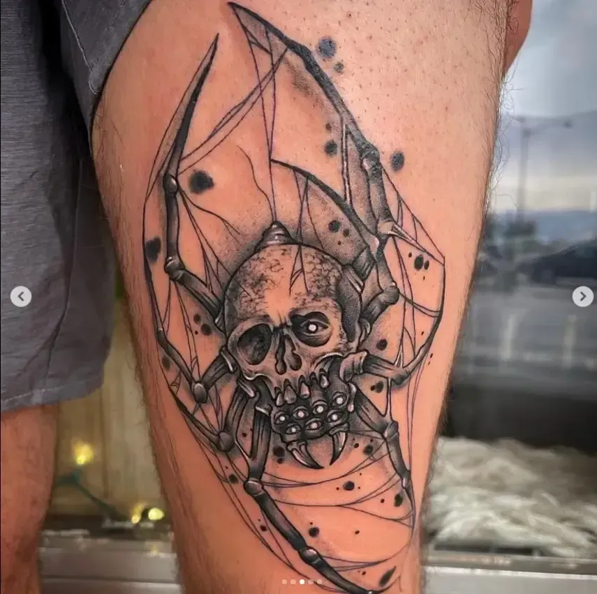 Black spiderweb skull tattoo on a calf with dark ink and geometric lines