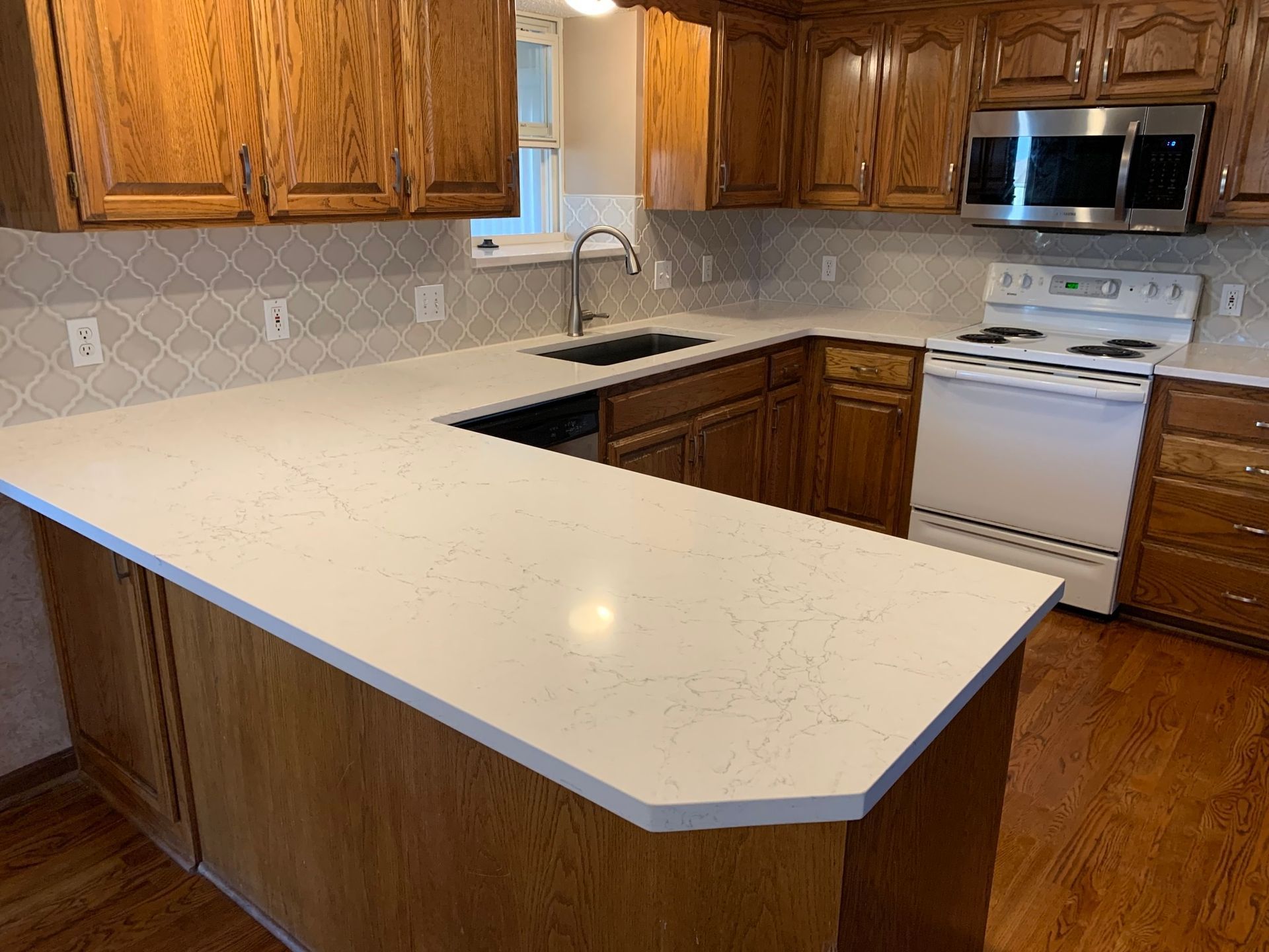 A kitchen with wooden cabinets and a white counter top.
