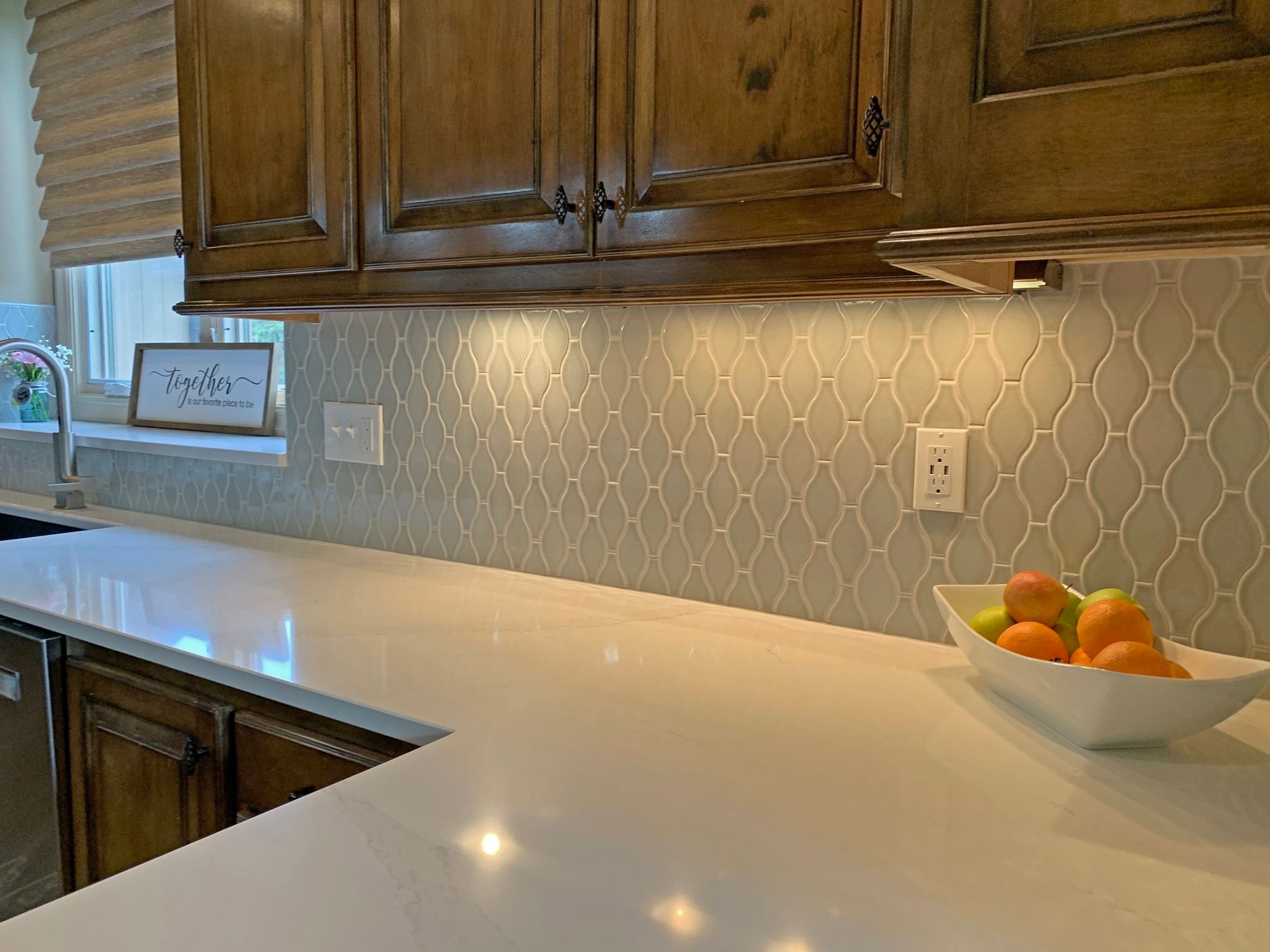 A kitchen counter with a bowl of oranges and lemons on it.
