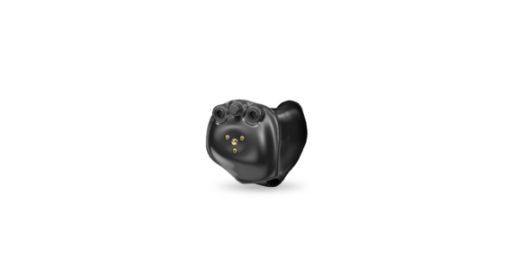 Black in-the-ear hearing aid with a gold charging contact, resting on a white background.