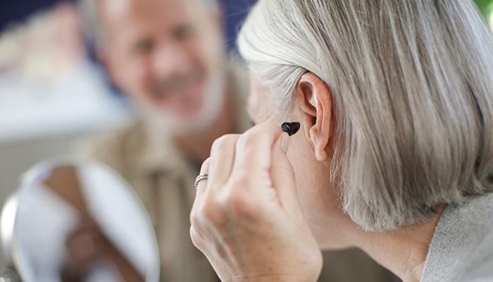 Black hearing aid with water splashing around it.