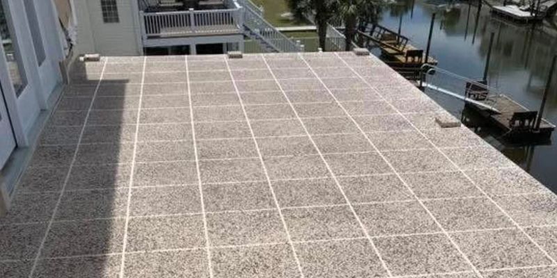 A large tiled patio with a view of a body of water.