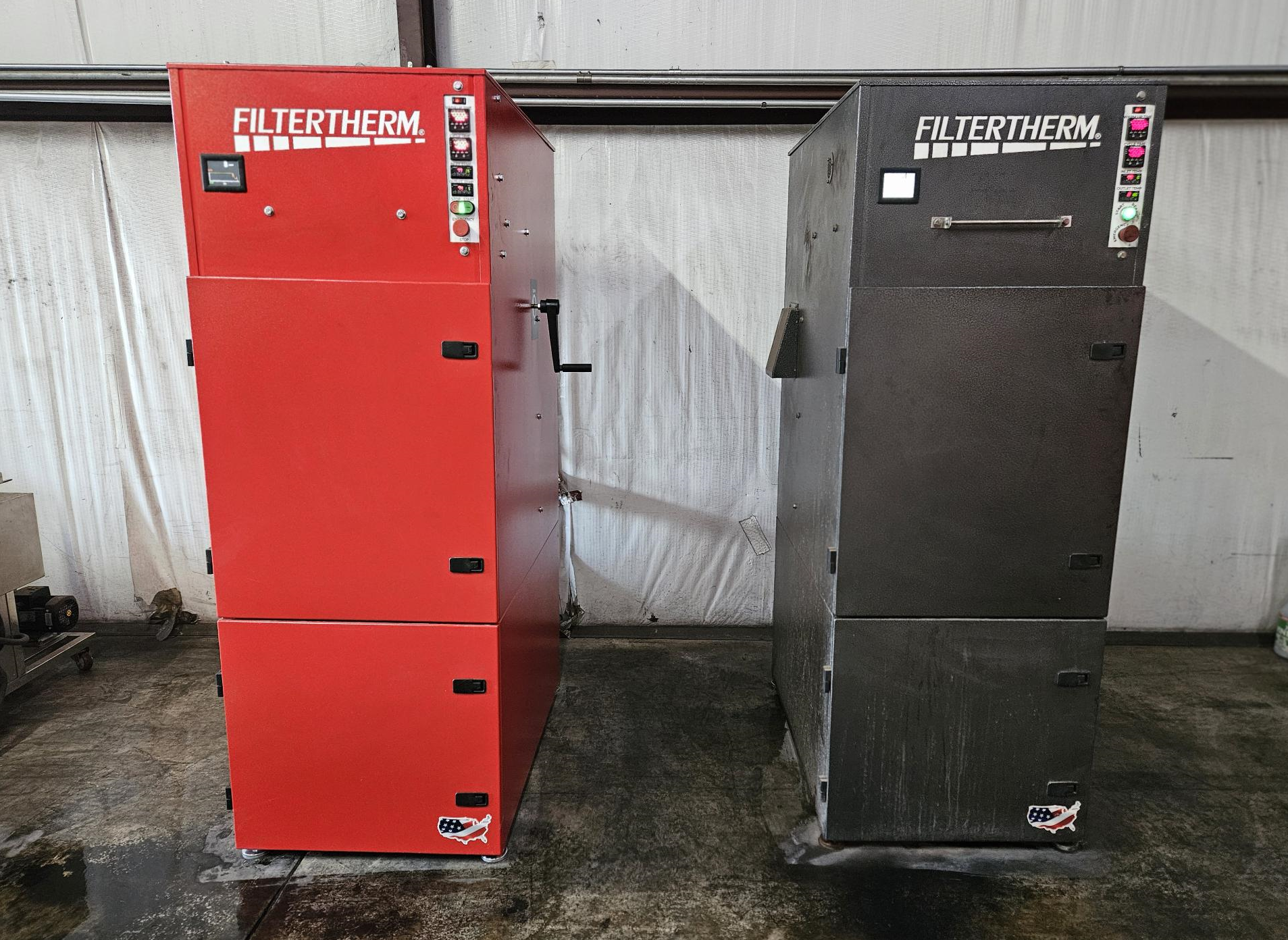 Two Filtertherm industrial waste oil heaters, one red and one black, standing side-by-side in a warehouse setting.