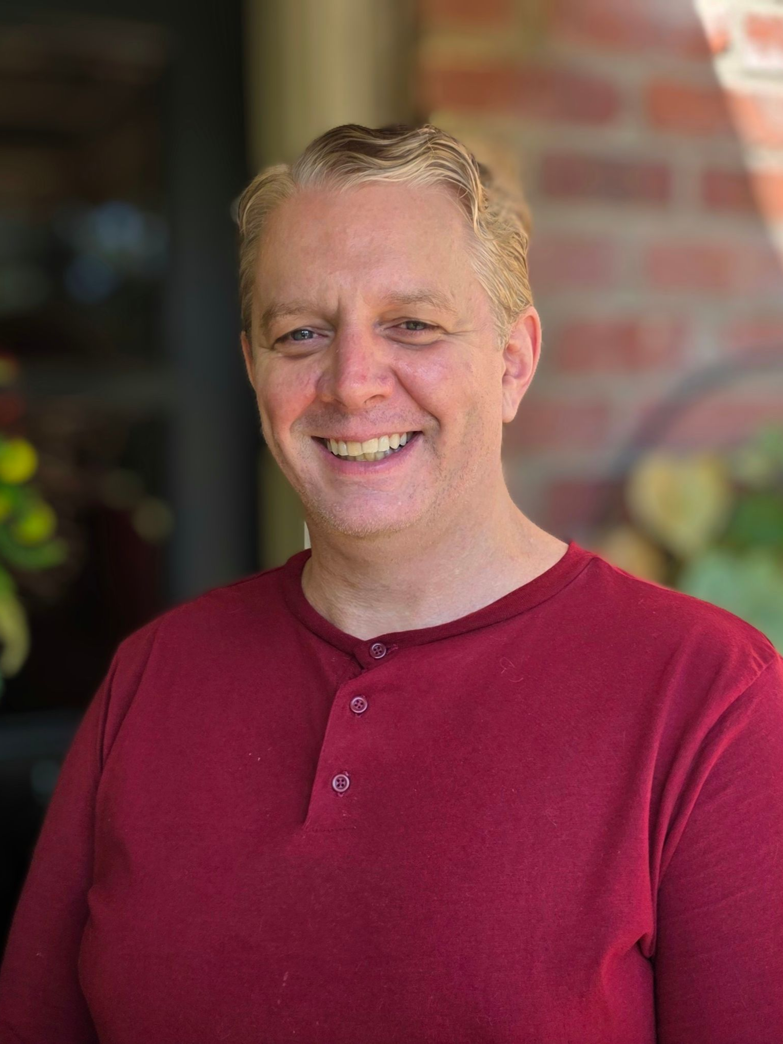 Jesse Byrd, LMT
Smiling man in red shirt, standing outdoors near brick wall and greenery.