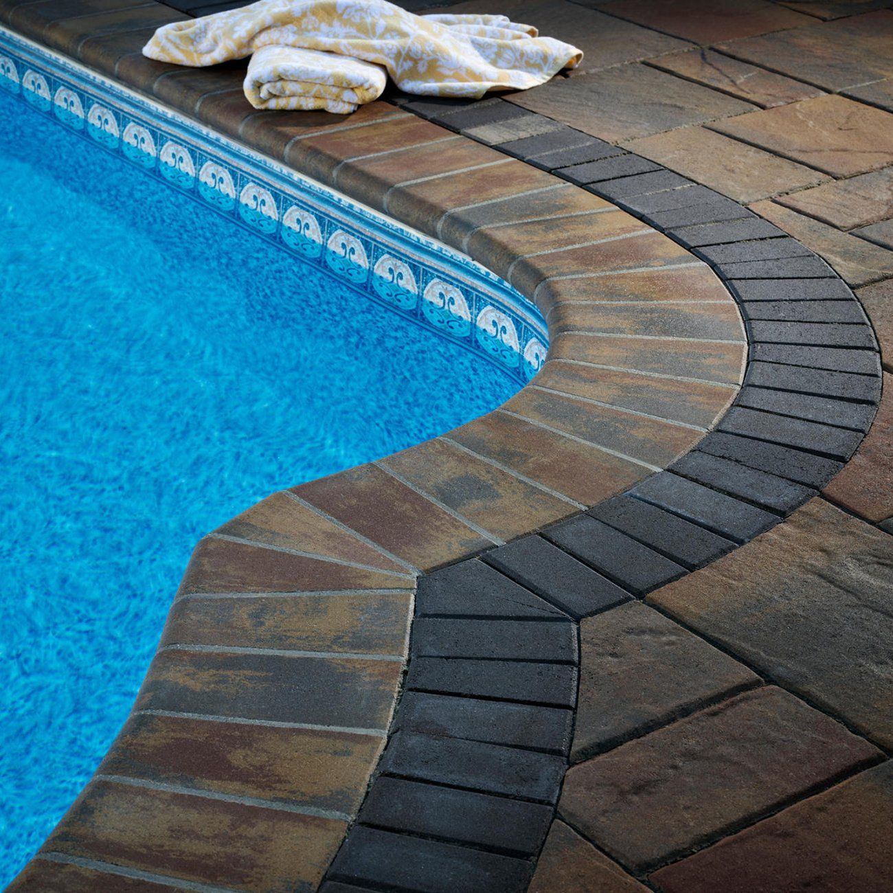 A towel is laying on the edge of a swimming pool
