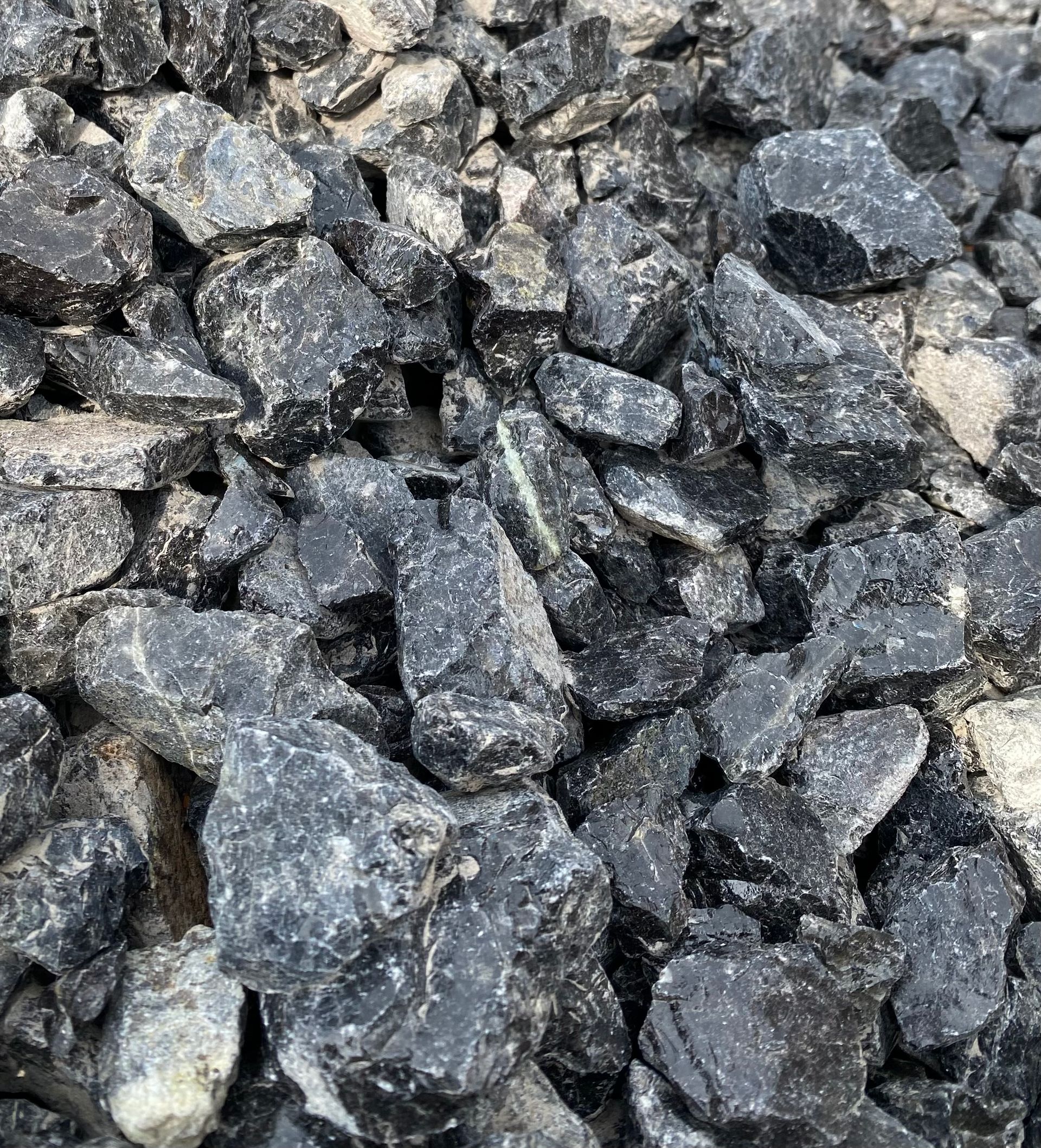 A pile of black rocks is sitting on the ground.