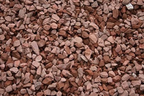 A pile of red gravel is sitting on the ground.