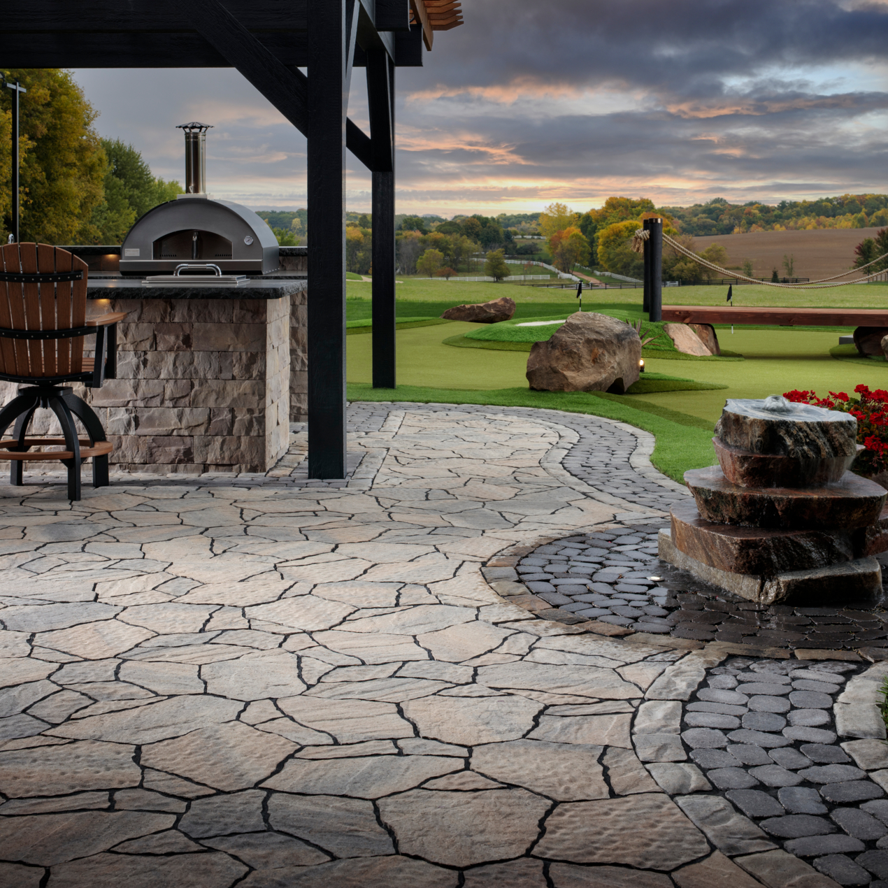 A stone patio with a pizza oven in the background