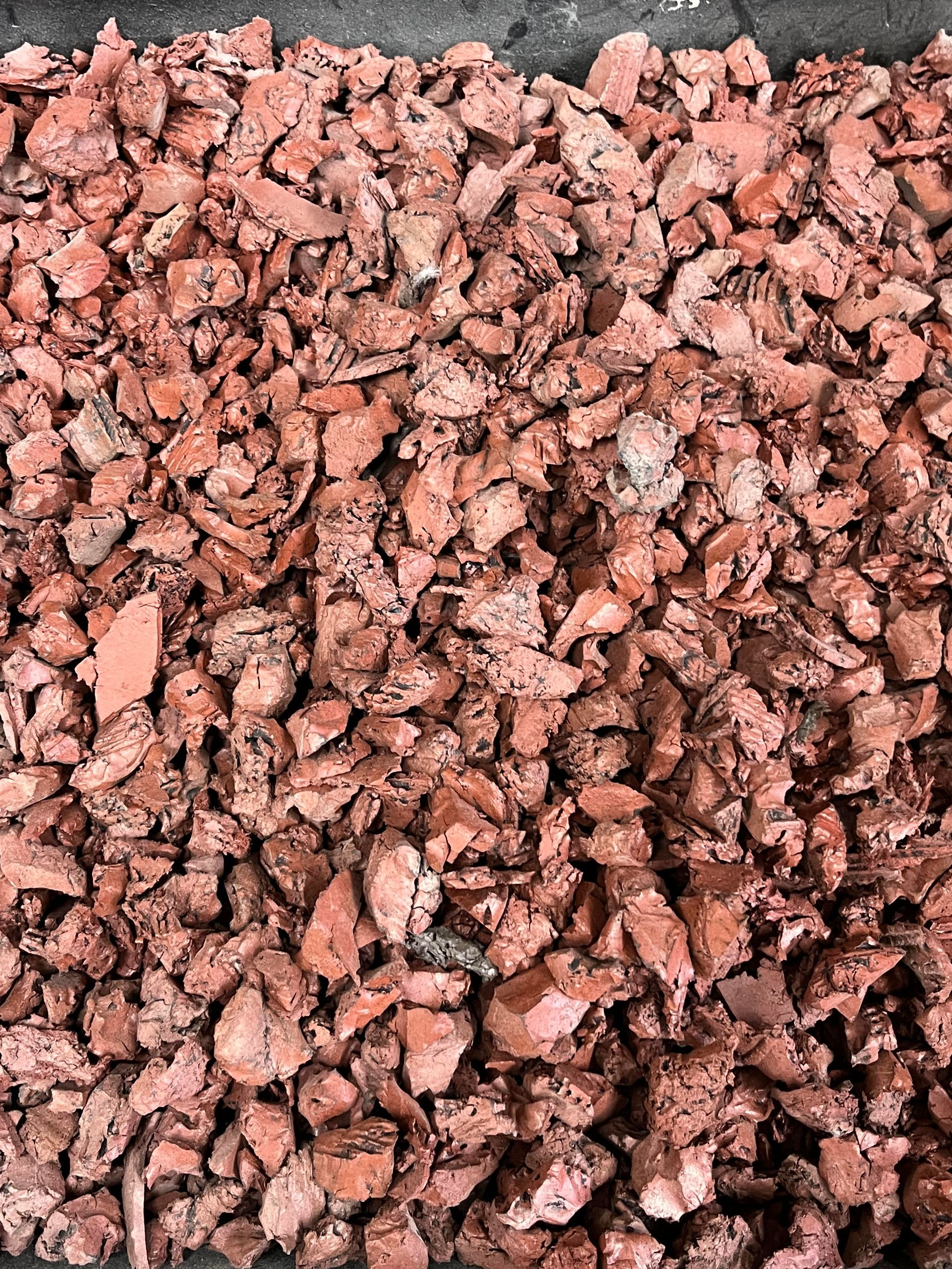 A pile of red gravel is sitting on a table.
