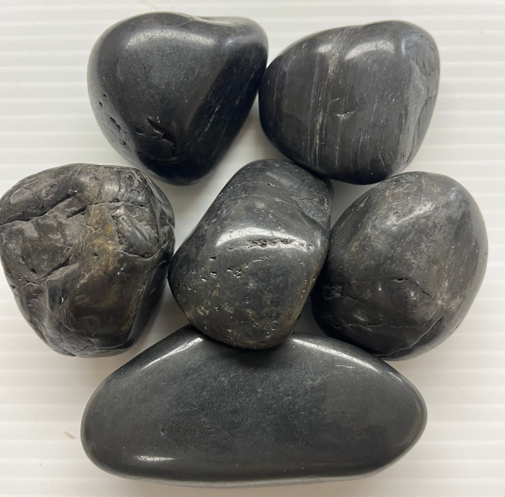 A pile of black rocks on a white surface