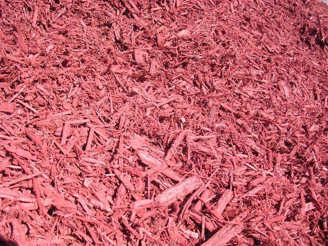 A pile of red mulch is sitting on the ground.