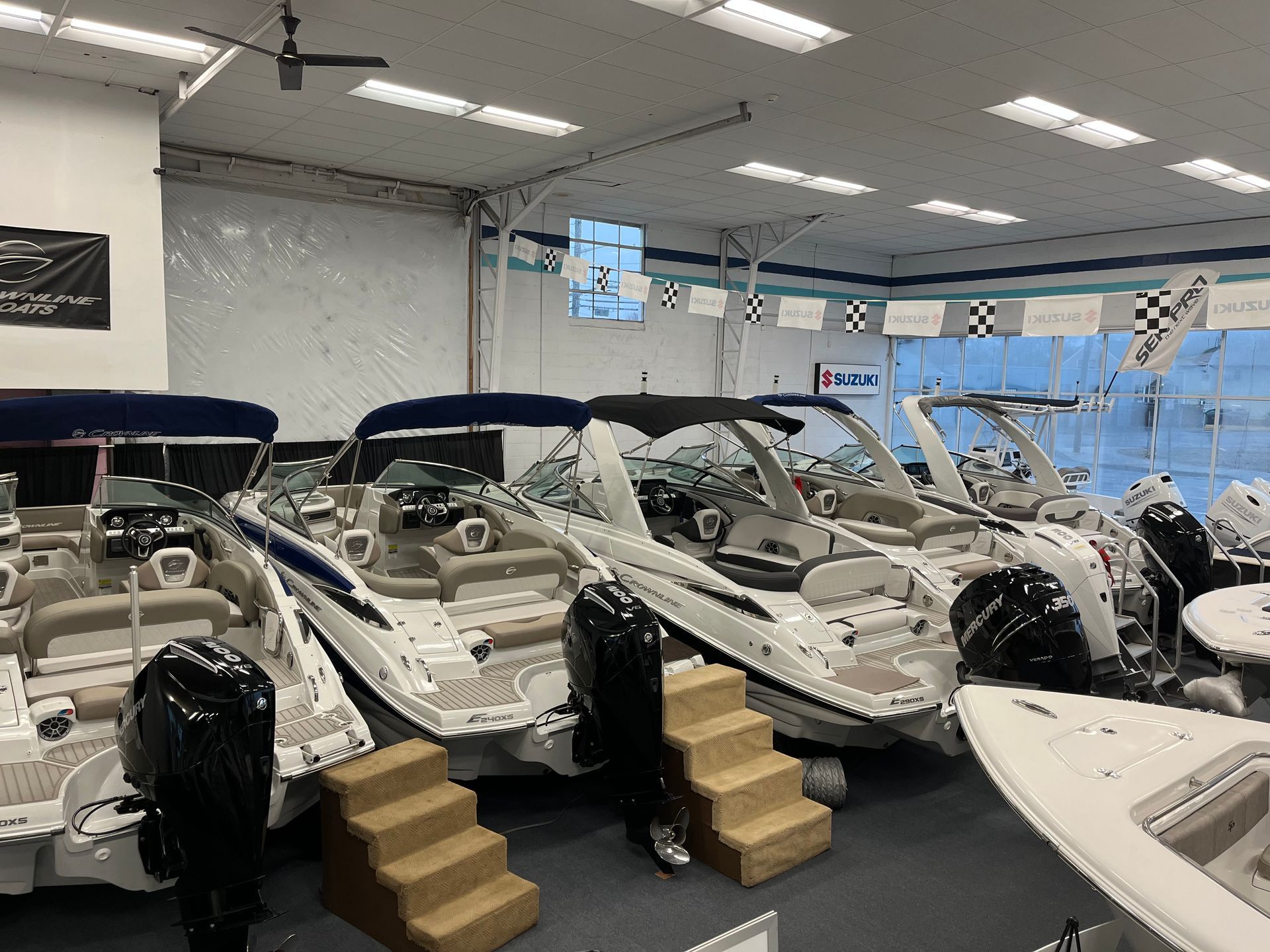 Several white boats in the showroom.