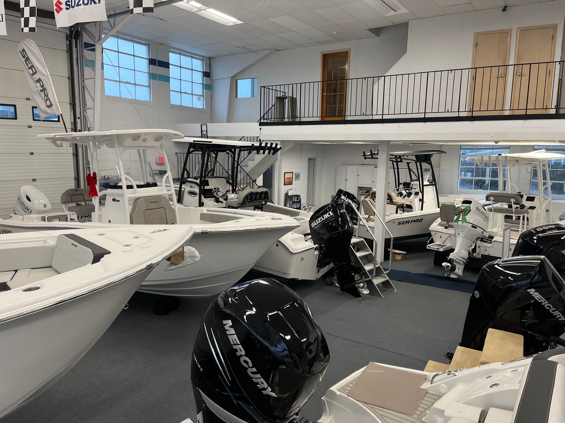 Several white boats in the showroom.
