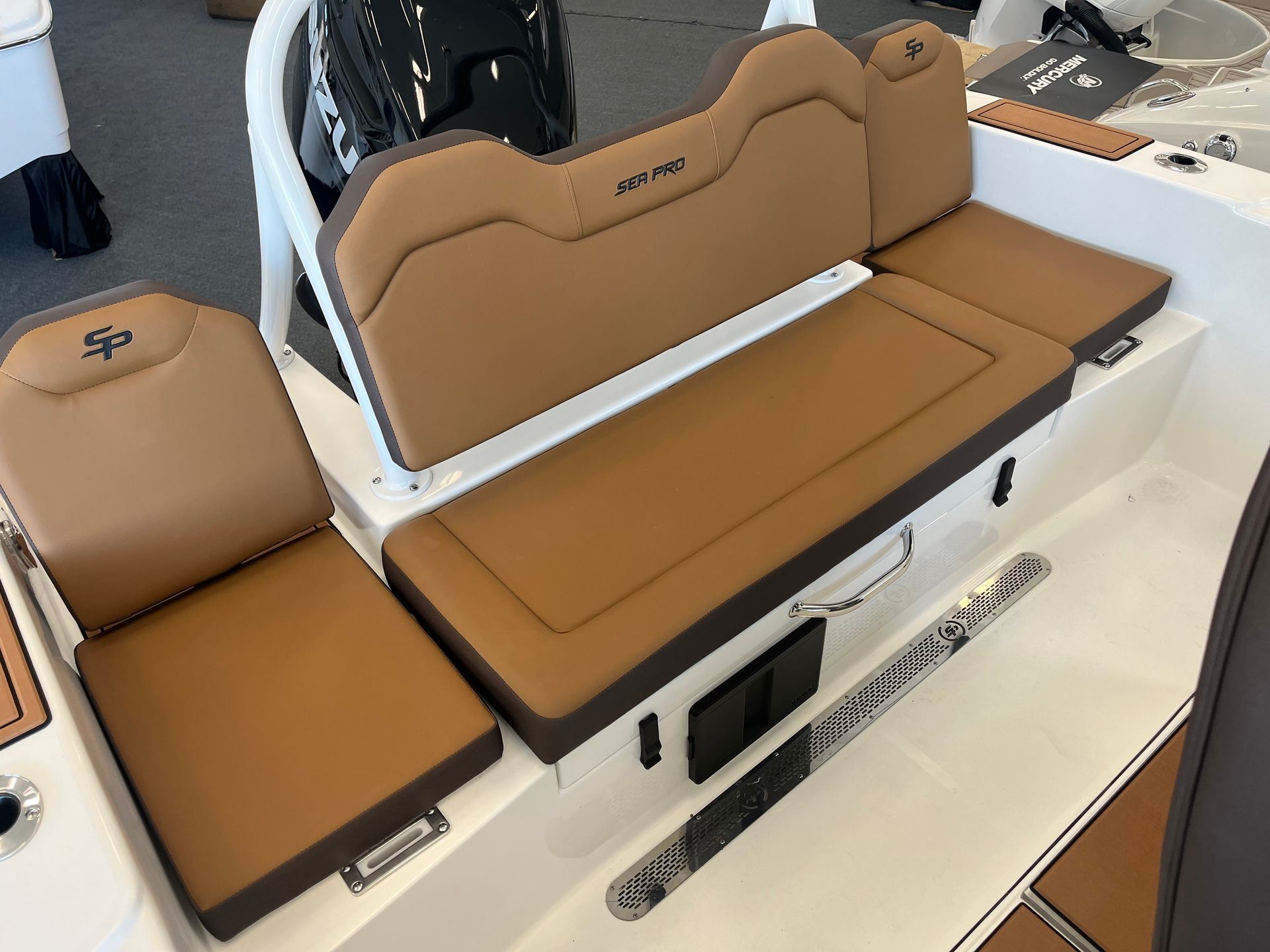 Boat interior with brown cushioned seats, a white frame, and dark accents.