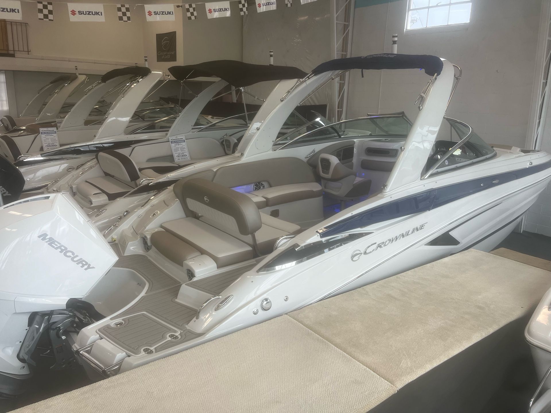 A row of boats are lined up in a showroom.