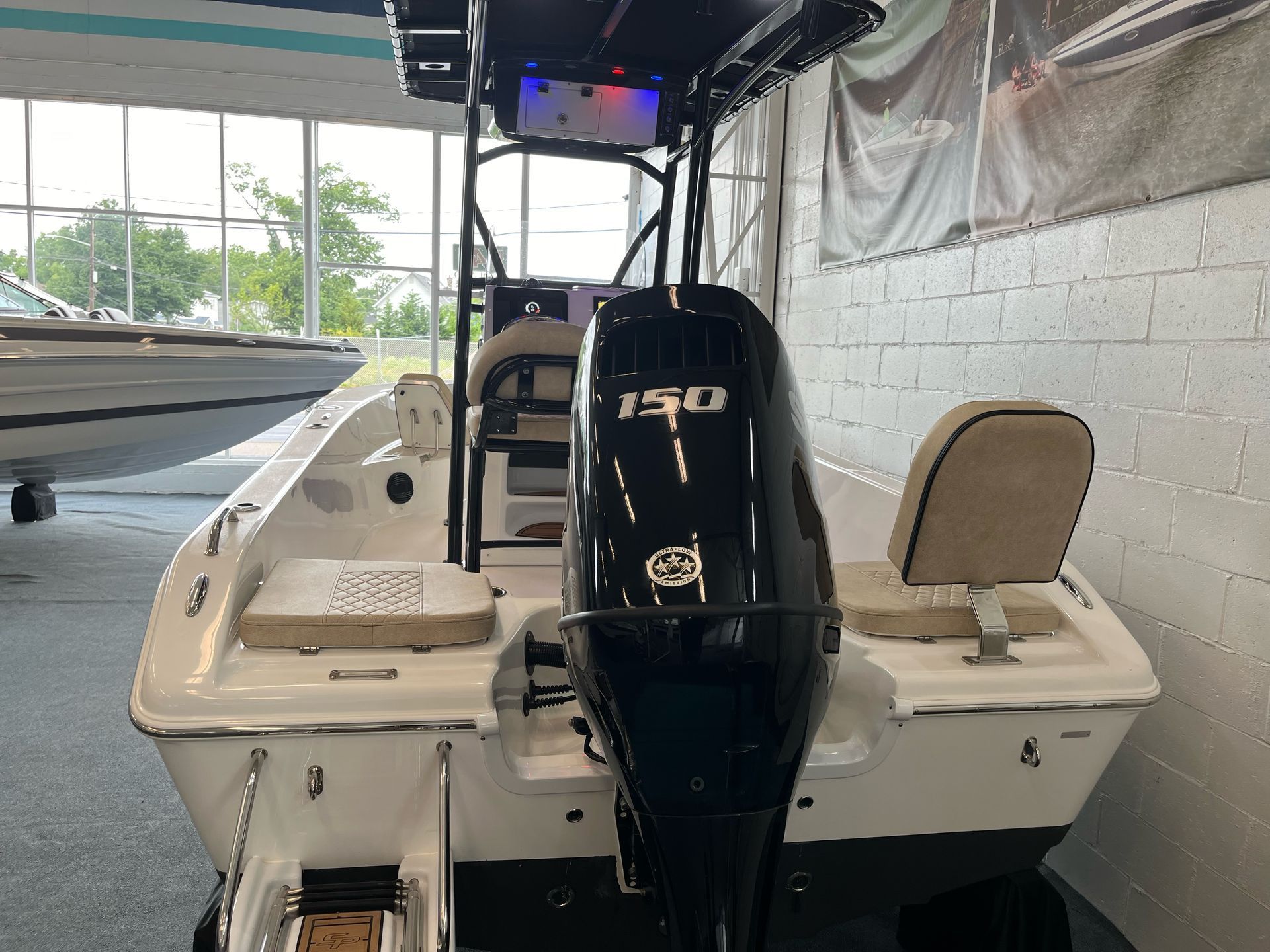 A boat with a 150 outboard motor is sitting in a showroom.