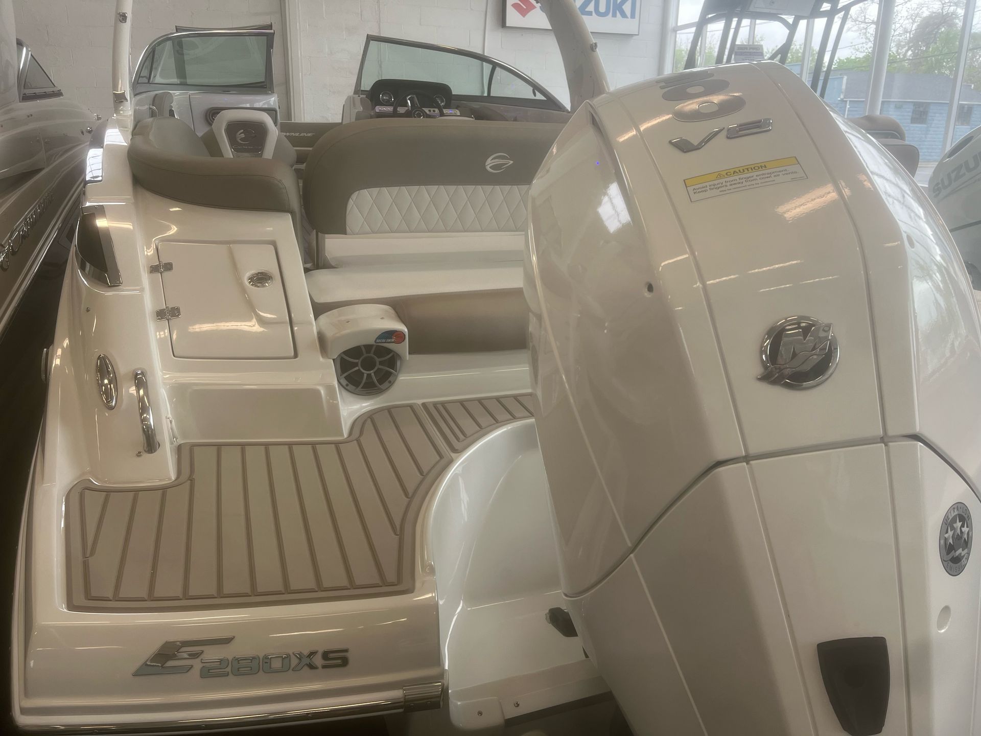 A boat with a suzuki outboard motor is sitting in a showroom.