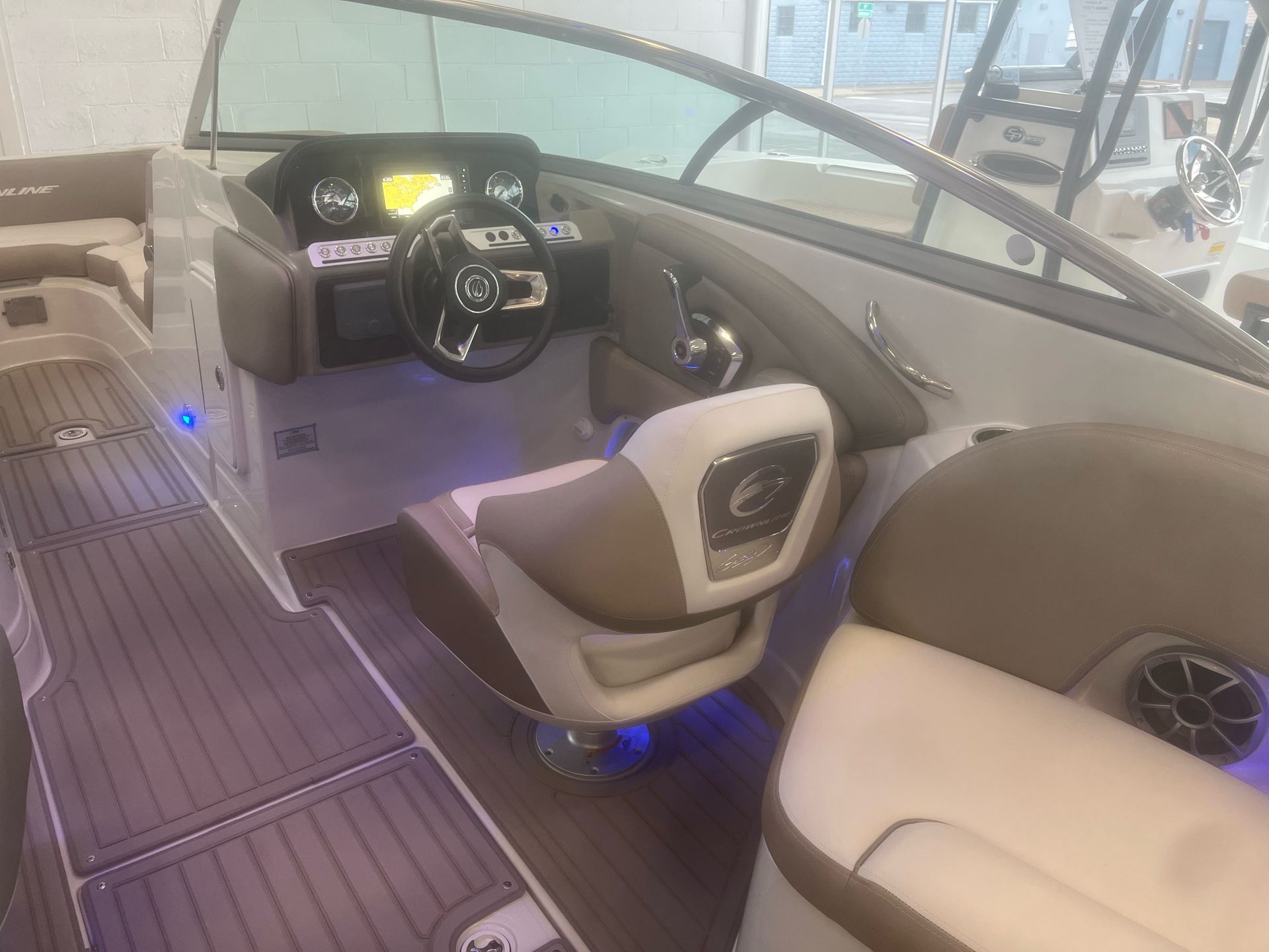 The interior of a boat with a steering wheel and seats.