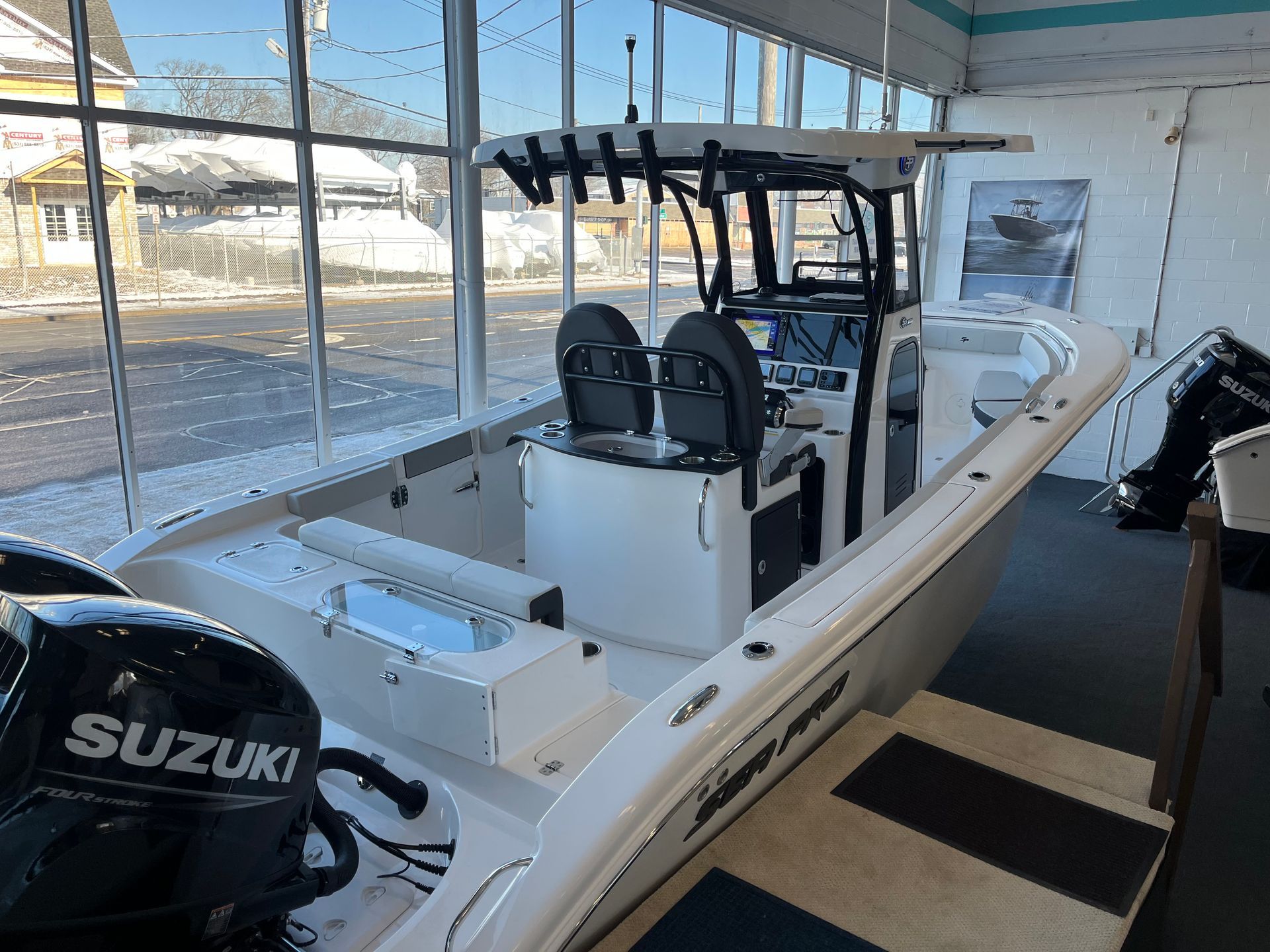 White fishing boat with a black frame inside a dealership.