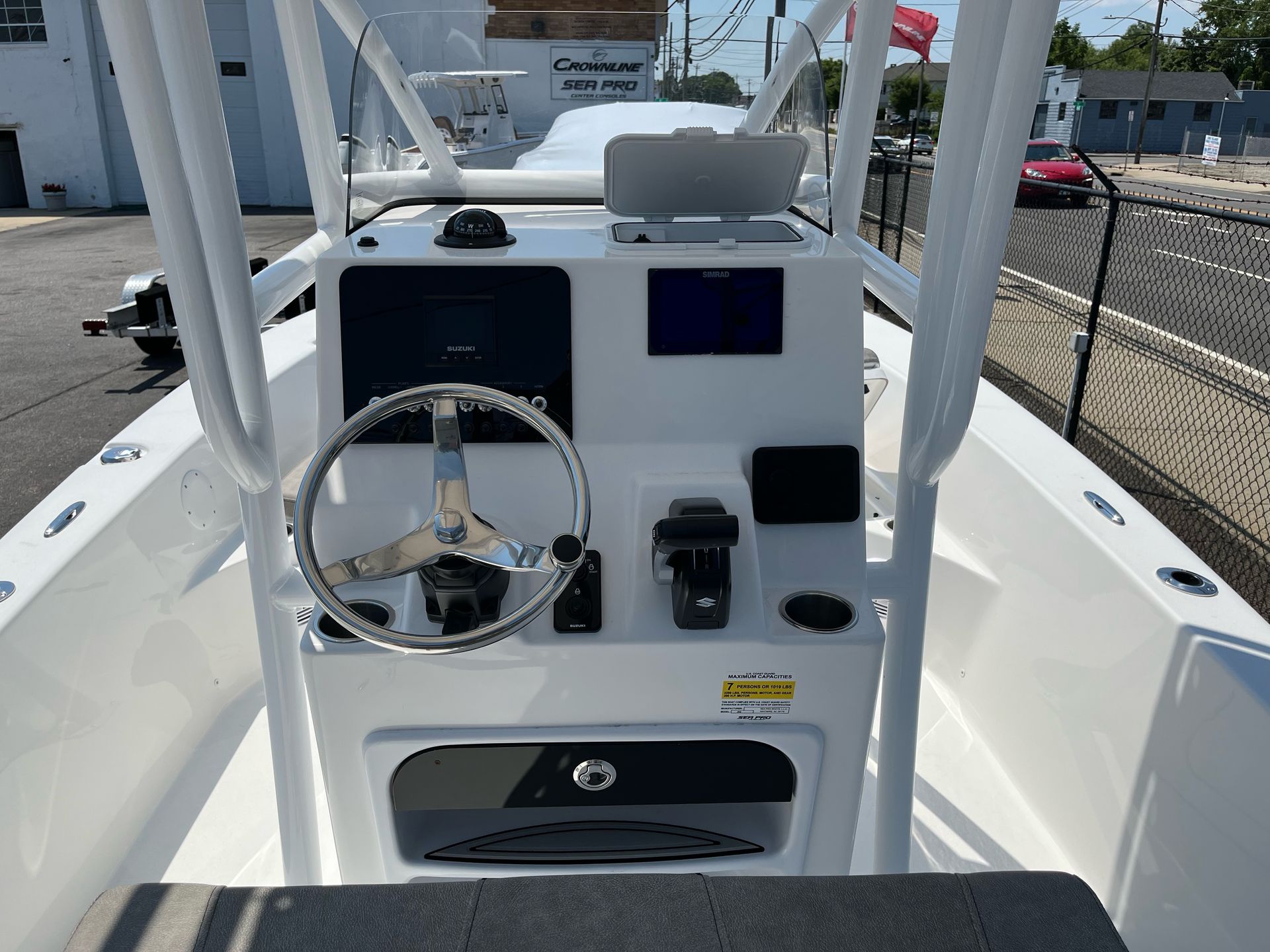 The front of a white boat with a steering wheel