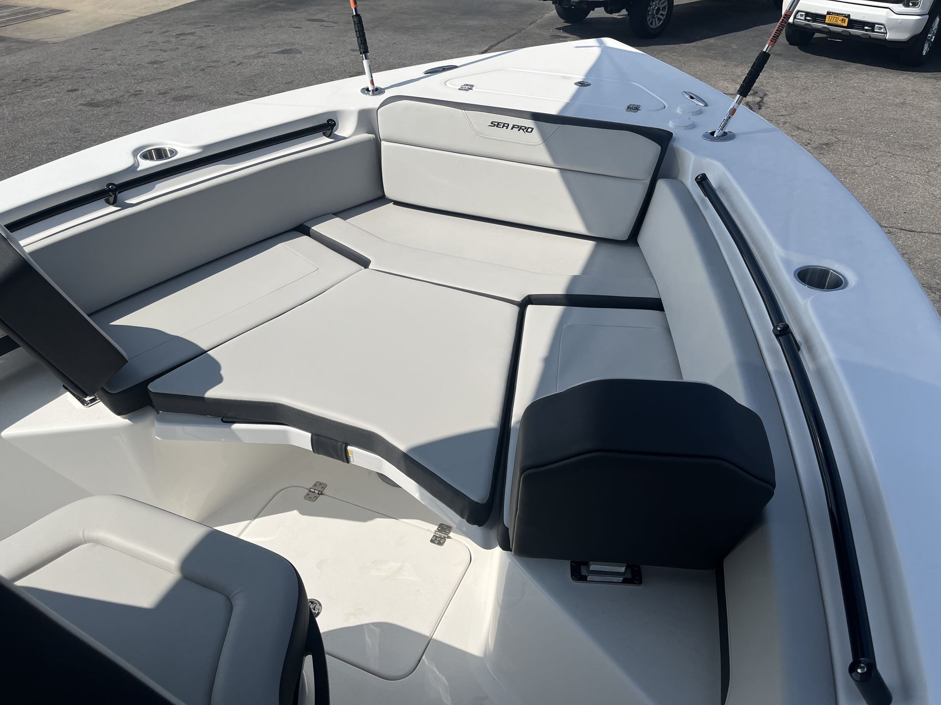 Boat interior with white and gray seats, fishing rod holders.