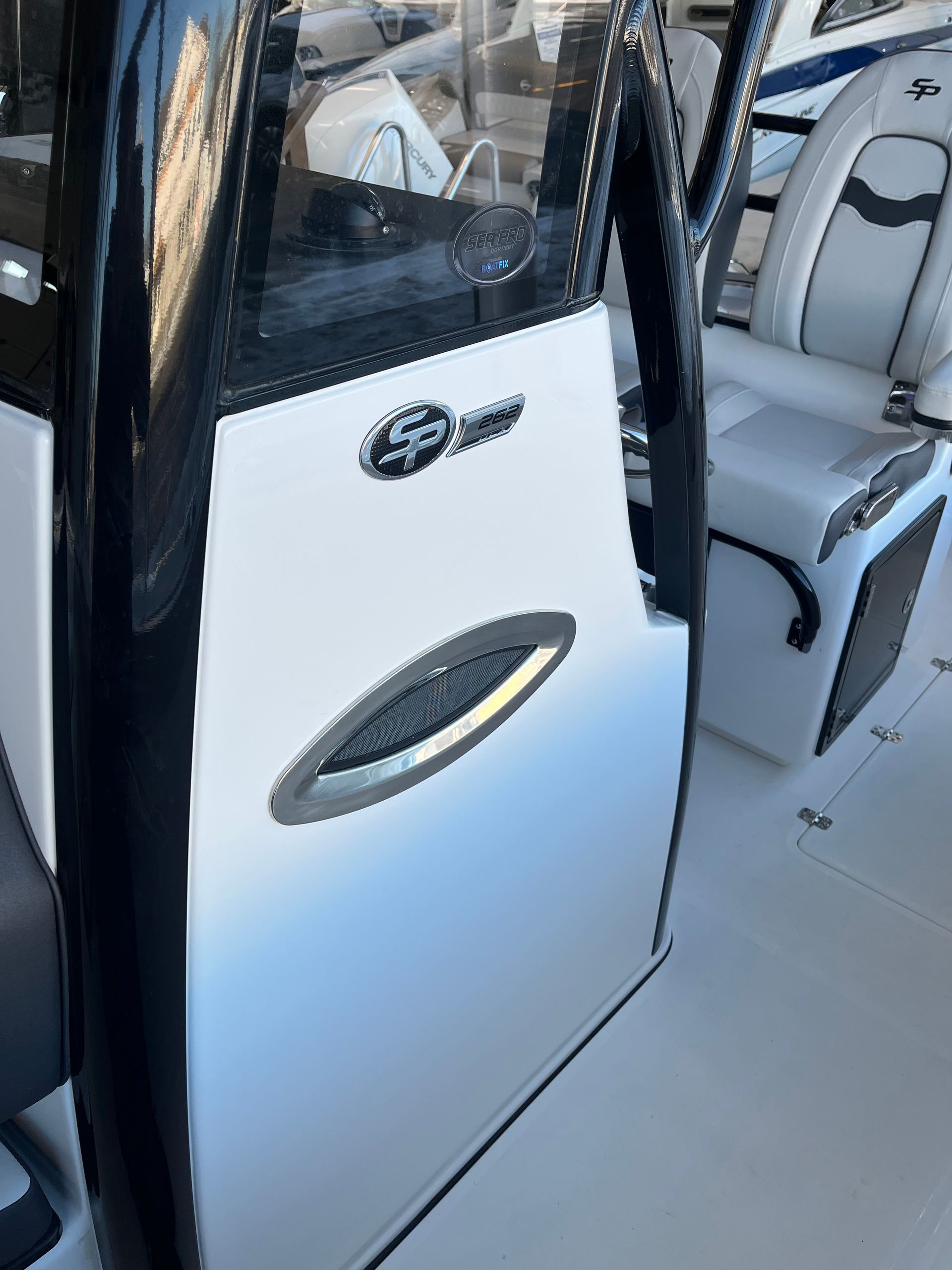 White and black boat console with logo, oval vent, and white seat.