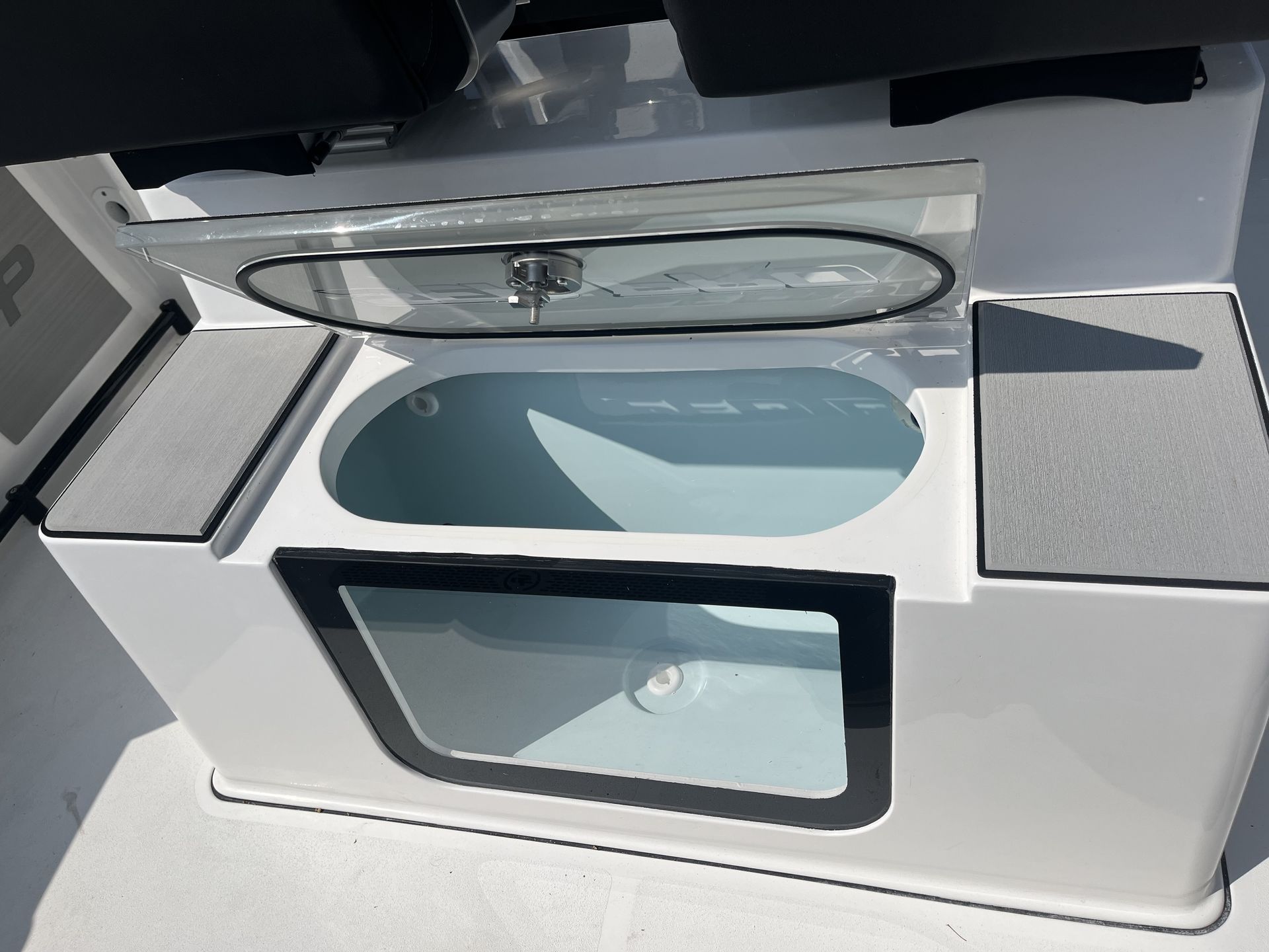 White boat fish-well with clear viewing window and lid open, with two gray padded areas.