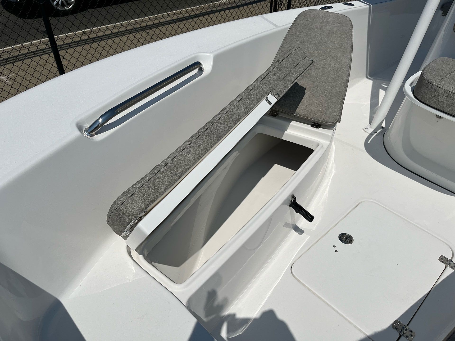 A white boat with the seat up and the trunk open
