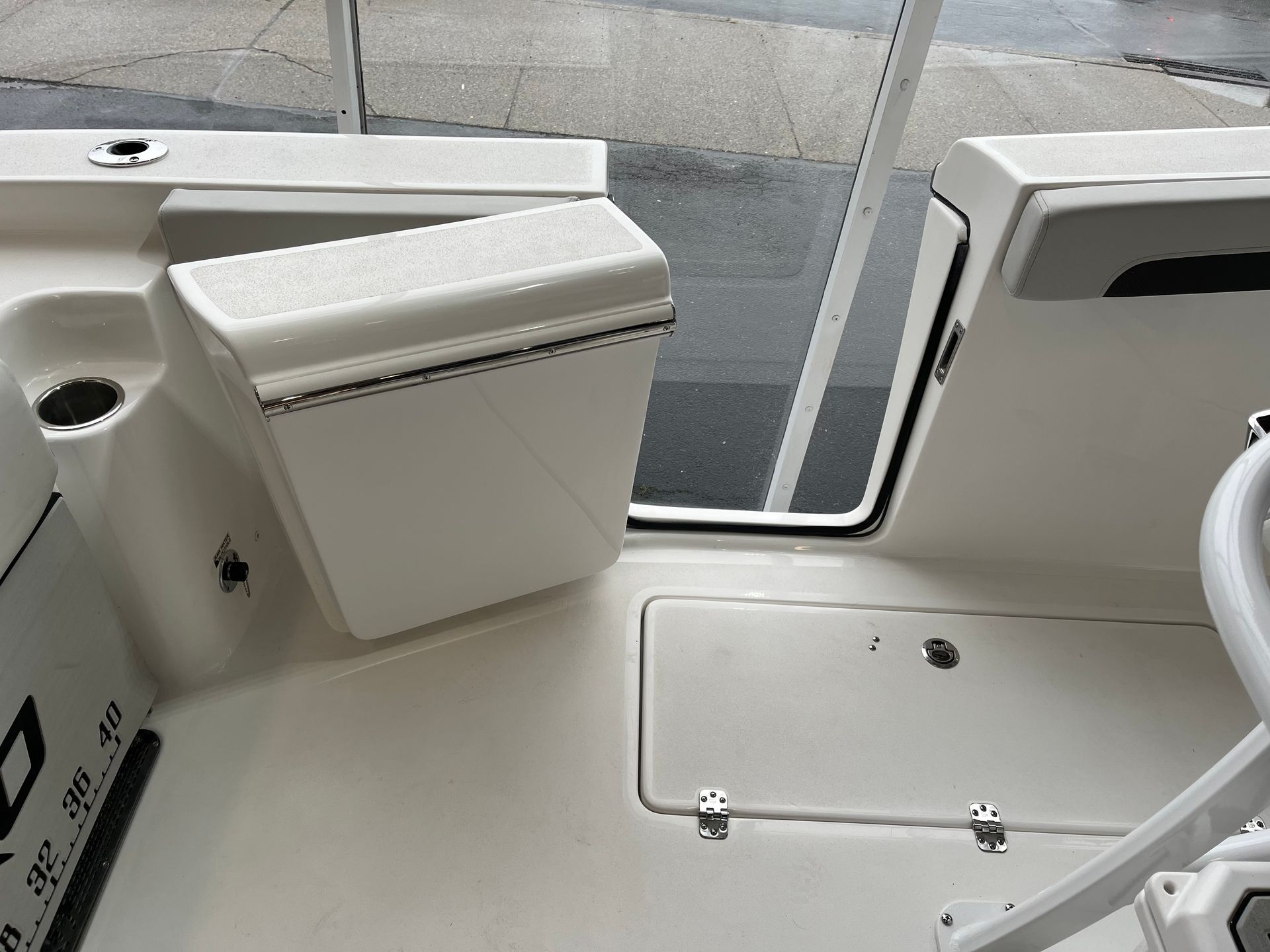 A white boat with the door open and a cooler on the deck