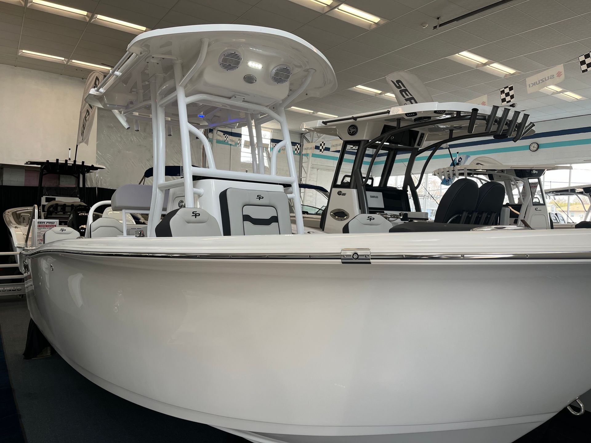 A white boat is sitting in a showroom.