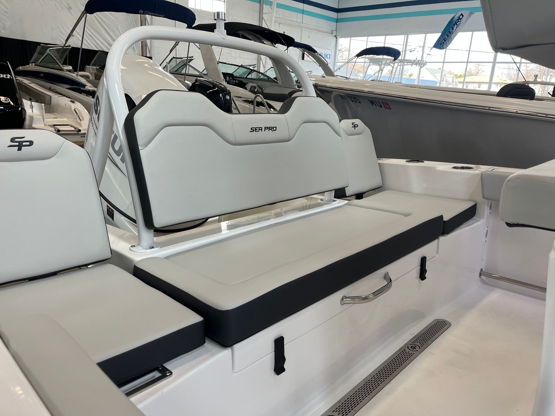 The back of a boat with a seat and a steering wheel in a showroom.