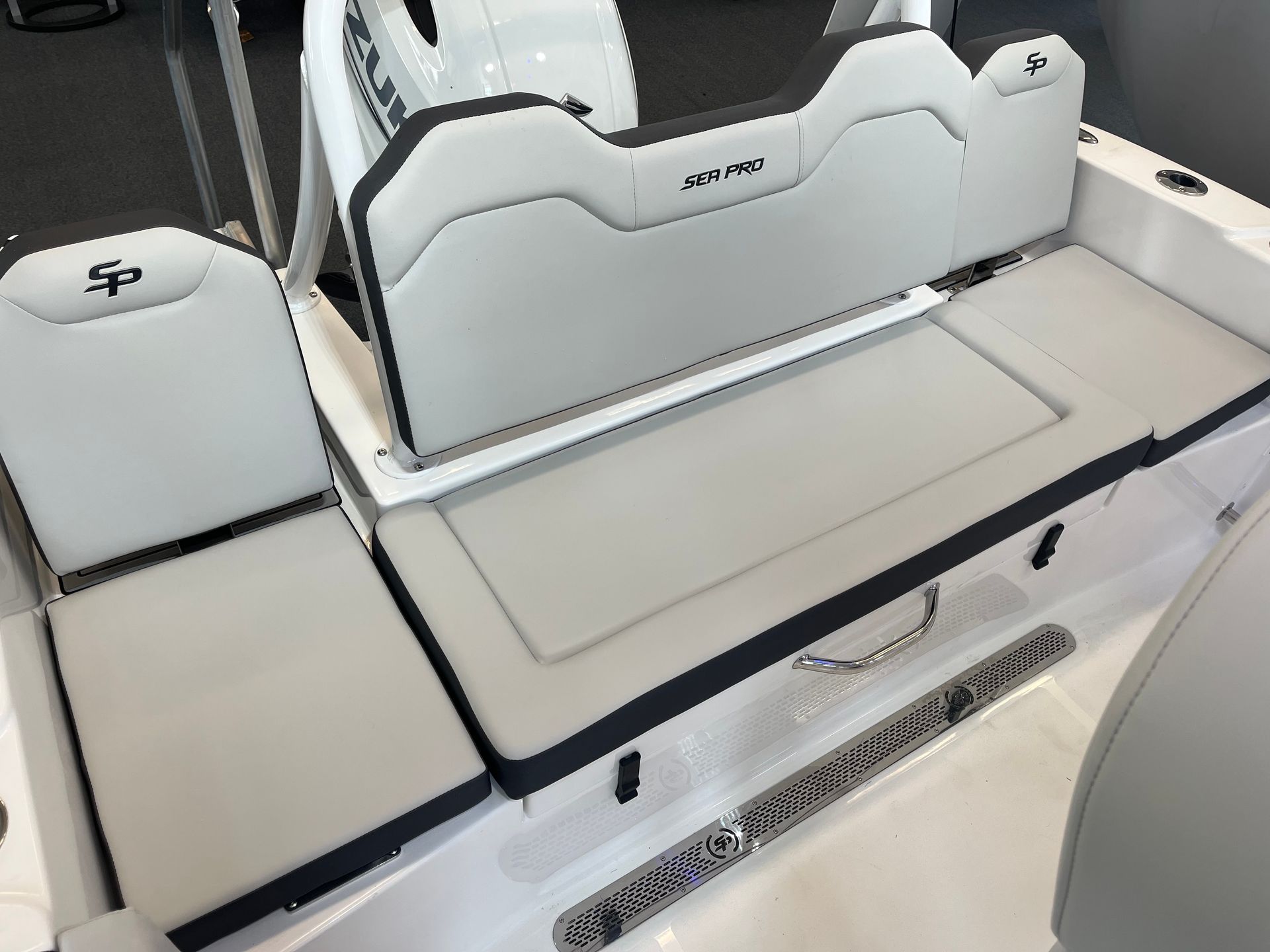 The back of a white boat with a cushioned seat.
