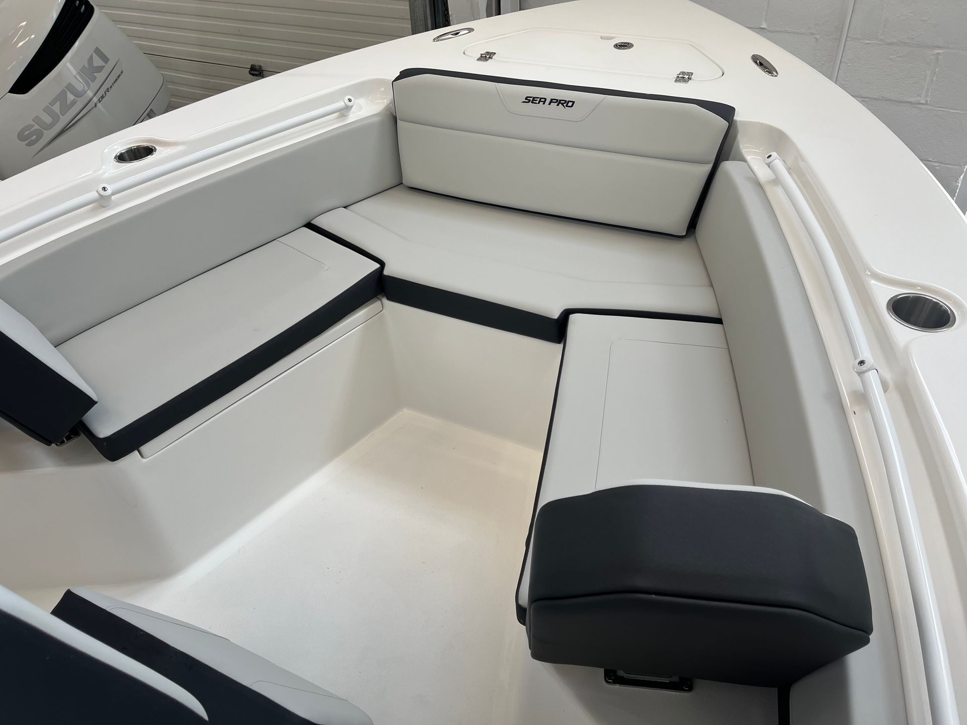 A white boat with black seats and a suzuki engine in the background